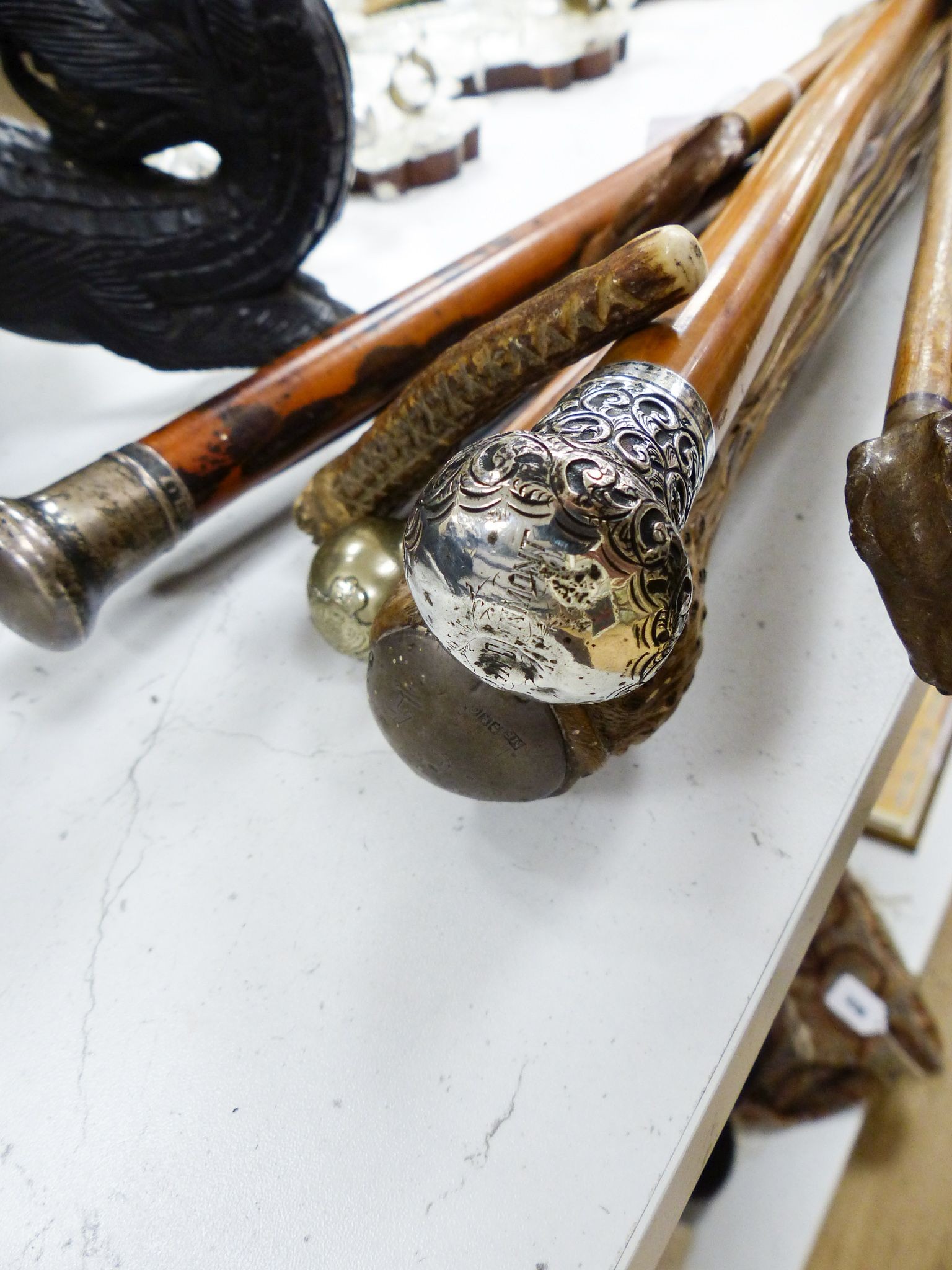 Three silver mounted canes, carved crops and tipstaffs